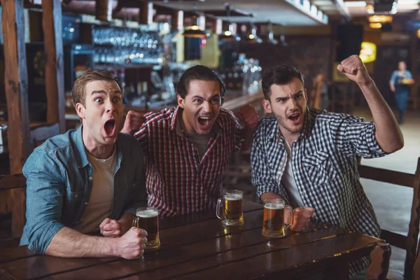 Three Young Men Casual Clothes Cheering Football Holding Glasses Beer — Stock Photo, Image