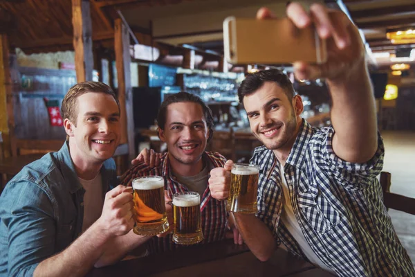 Trzech Młodych Mężczyzn Ubranie Uśmiechnięte Biorąc Selfie Picia Piwa Siedząc — Zdjęcie stockowe