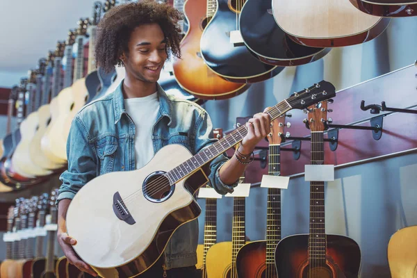 Afro Amerikan Yakışıklı Bir Gitar Tutarak Müzikal Bir Dükkanda Duran — Stok fotoğraf