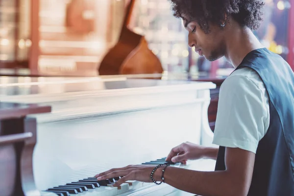 音楽店でピアノを弾くクラシック ベストでハンサムなアフリカ系アメリカ人男性 — ストック写真
