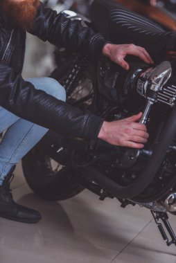 Onun motosiklet, yakın çekim yakışıklı genç sakallı adam siyah deri ceketli incelenmesi