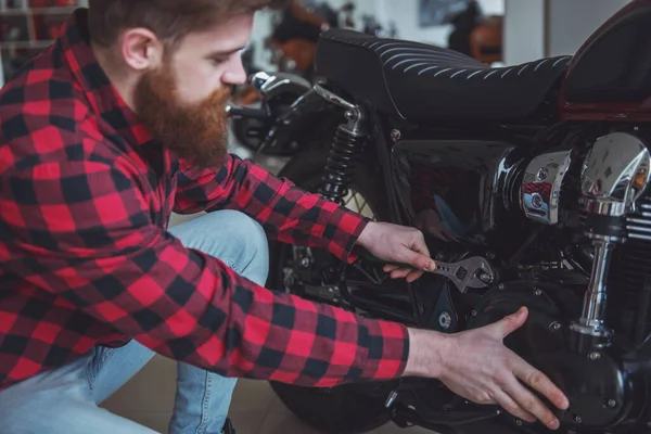 Bonito Jovem Barbudo Homem Roupas Casuais Está Reparando Uma Moto — Fotografia de Stock