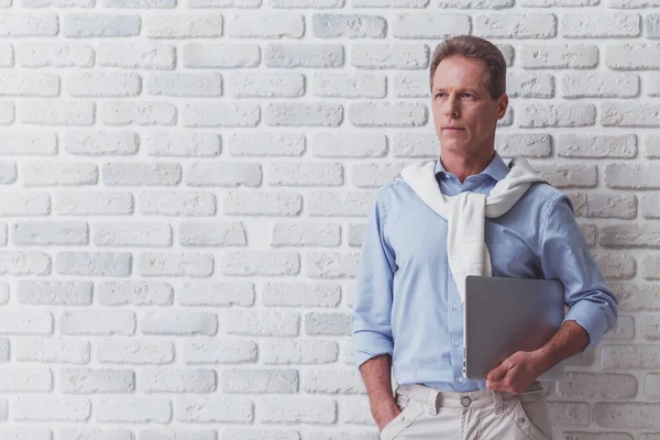 Handsome Middle Aged Man Holding Laptop Looking Away While Standing — Stock Photo, Image
