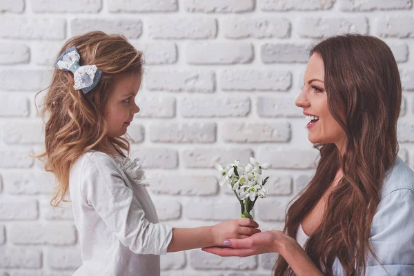 Sevimli Küçük Kız Güzel Genç Anne Beyaz Tuğla Duvara Çiçek — Stok fotoğraf