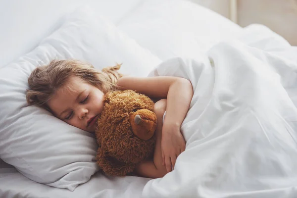 Doce Menina Está Abraçando Ursinho Pelúcia Enquanto Dorme Sua Cama — Fotografia de Stock