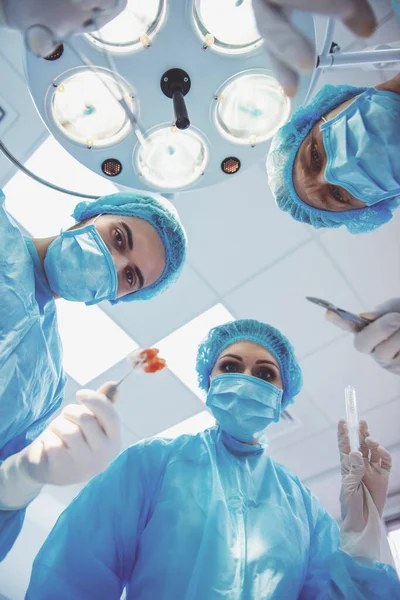 在一个现代化的手术室里 外科医生们正在用医疗仪器进行一项手术 — 图库照片
