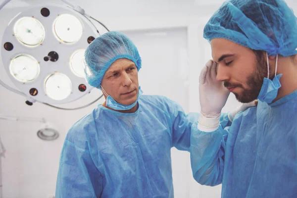 Bel Giovane Dottore Mal Testa Suo Collega Sta Calmando Piedi — Foto Stock