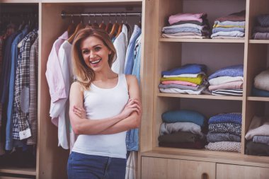 Güzel kız gülümseyerek ve soyunma odasına kamera çapraz kolları olan dururken bakarak