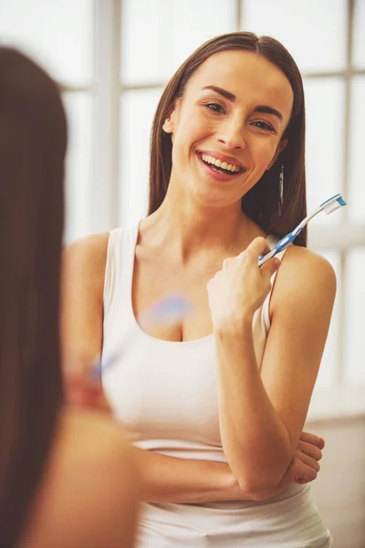 Schöne Junge Frau Hält Eine Zahnbürste Blickt Die Kamera Und — Stockfoto