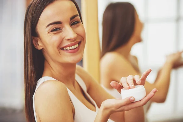 Bella Ragazza Sta Tenendo Barattolo Crema Guardando Fotocamera Sorridendo Piedi — Foto Stock