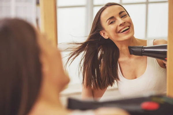 Hermosa Chica Está Haciendo Cabello Usando Secador Pelo Sonriendo Mientras —  Fotos de Stock