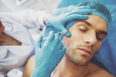 Kapalı gözlerle yalan yüz içinde bir enjeksiyon almak yakışıklı genç adam portresi