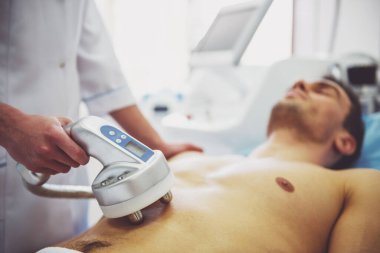 Yakışıklı adam cilt tedavi olmaya başladı. Kadın doktor modern ekipman kullanarak yordamı taahhüt