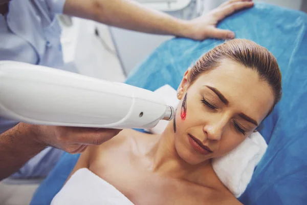 美丽的女人正在脸上的皮肤治疗 医生正在采用一种现代设备的程序 — 图库照片