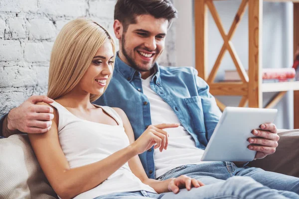 Beautiful Young Couple Using Tablet Hugging Smiling While Sitting Sofa — Stock Photo, Image