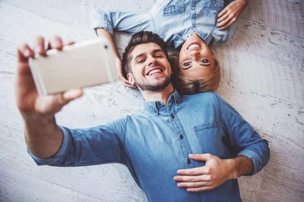 Evde Yerde Yatarken Akıllı Telefon Kullanarak Selfie Çeken Gülümseyen Genç — Stok fotoğraf