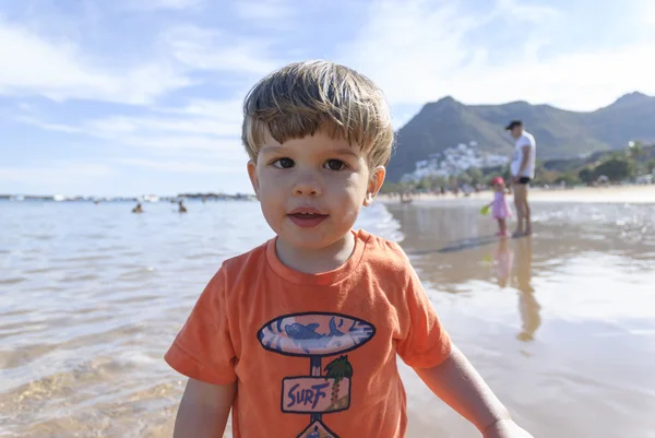 Niño jugando en la playa con cubo rojo —  Fotos de Stock