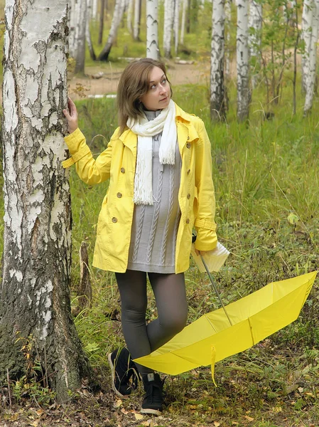 Girl in autumn forest with yellow umbrella — Stock Photo, Image