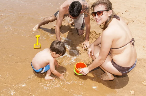 Šťastná rodina hraje na pláži — Stock fotografie