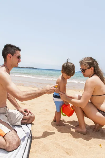 Счастливая семья, играющая на пляже — стоковое фото
