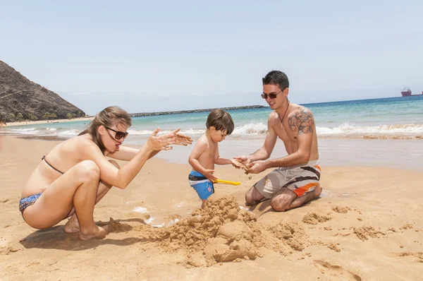 Šťastná rodina hraje na pláži — Stock fotografie