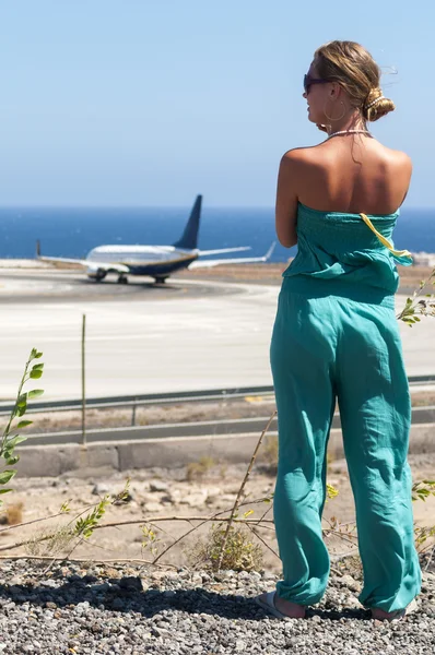 Beautiful blondy with long hair looking at airplane — Stock Photo, Image