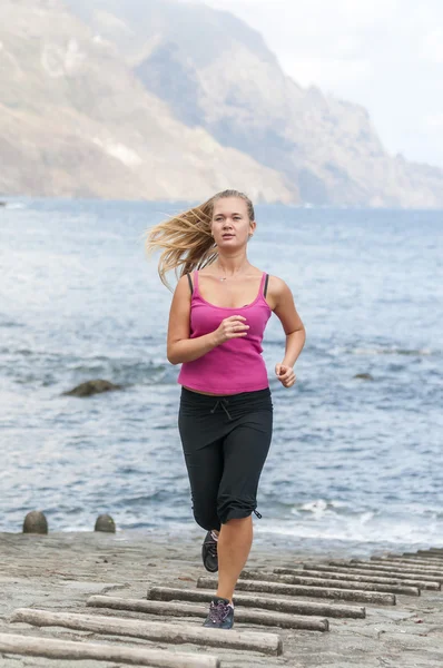 Mujer joven y saludable corriendo en la playa — Foto de Stock