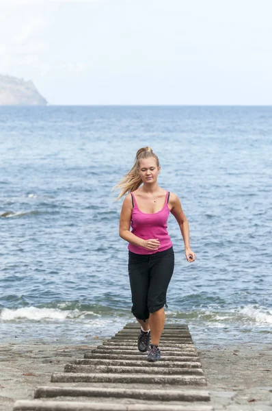 Healthy young woman running on the beach — Stock Photo, Image