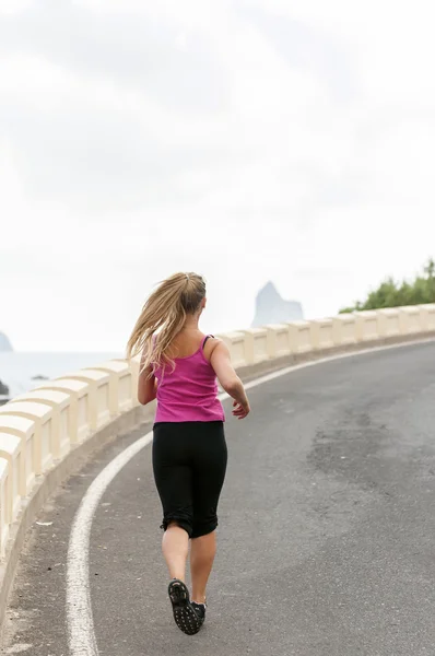 Fitness. bir dağ yolunda çalışan genç bir kadın — Stok fotoğraf