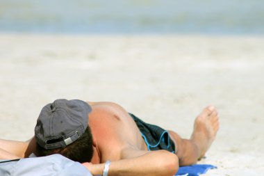 man om te zonnebaden op het strand