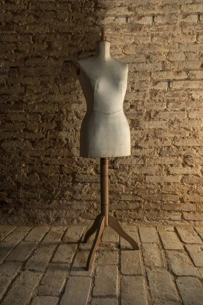 Eski duvarın arka planında eski bir manken 