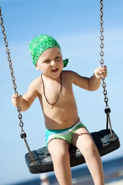 Jongen swingen met een grote glimlach — Stockfoto