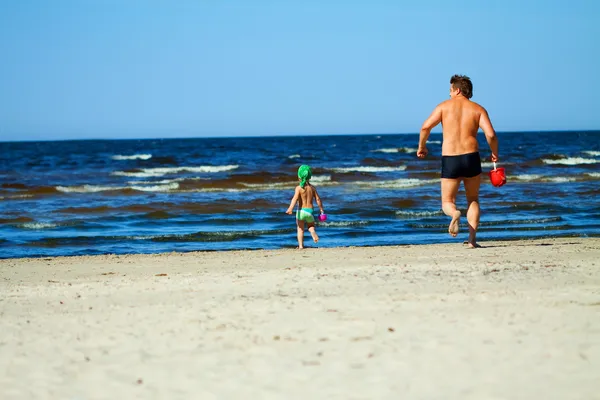 Family of two frolicking on the beach. Stock Photo