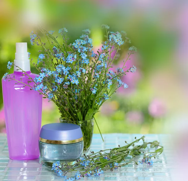 Kosmetika flaskor med blommor — Stockfoto
