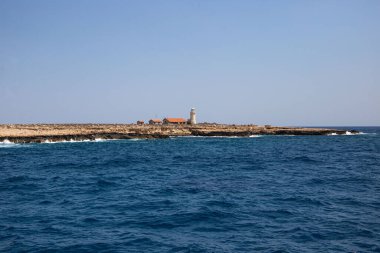 Denizdeki bir adada yalnız bir deniz feneri.