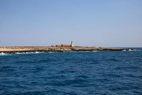 Denizdeki bir adada yalnız bir deniz feneri.