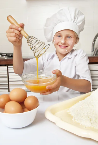 Weinig meisje kloppend eieren — Stockfoto