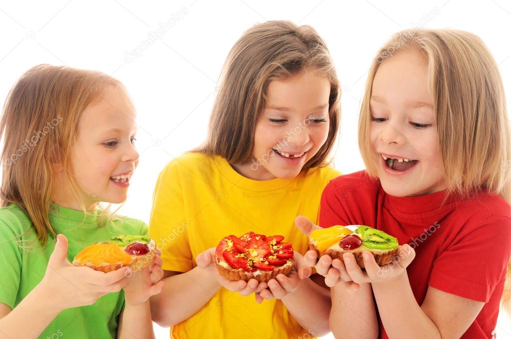 Kids eating cake with cream and fruits