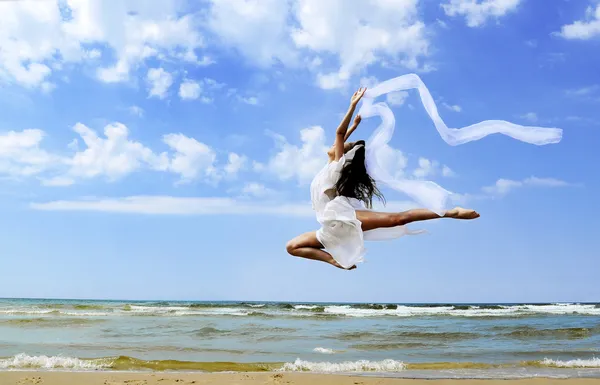 Mooi meisje springen op het strand — Stockfoto