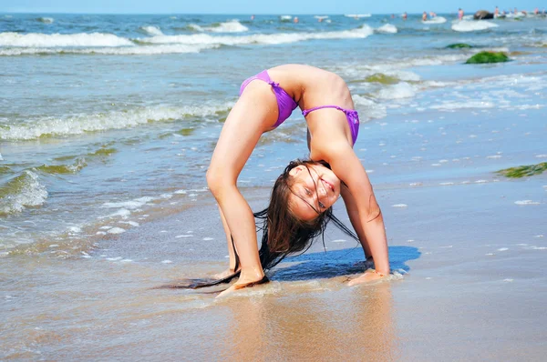 Elastyczne dziewczynka gra na plaży — Zdjęcie stockowe