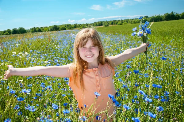 Kislány és virágok a réten — Stock Fotó