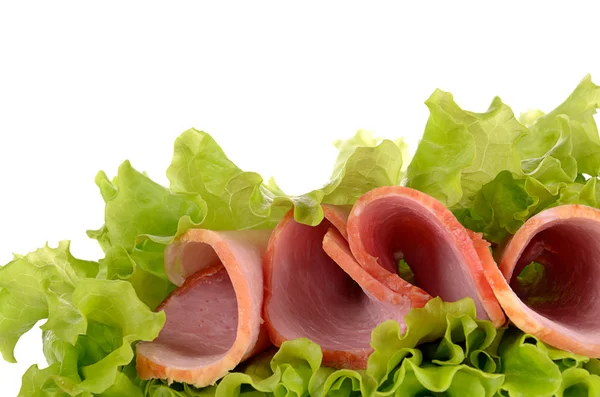 Fette di prosciutto su insalata verde, isolate su fondo bianco — Foto Stock