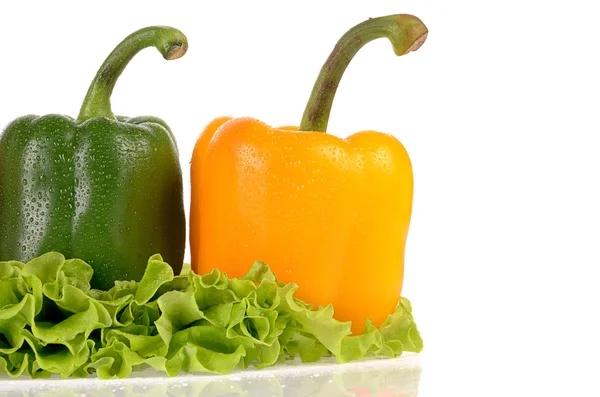 Pimientos verdes y amarillos en hojas de ensalada — Foto de Stock