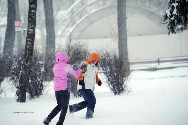 Snowball fight. Winter couple having fun playing in snow outdoor — Stock Photo, Image