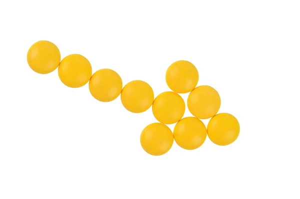 Flèche de pilules jaunes sur fond blanc — Photo
