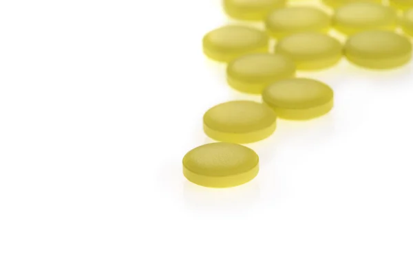 Пачка желтых таблеток на белом фоне — стоковое фото