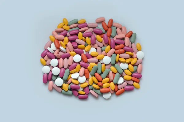 Stack of different pills isolated on gray background — Stock Photo, Image