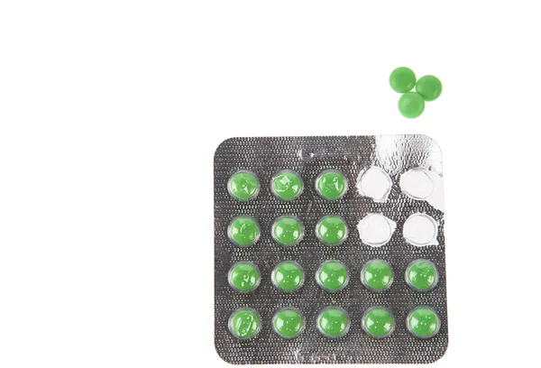 Зеленые таблетки в волдырях на белом фоне — стоковое фото