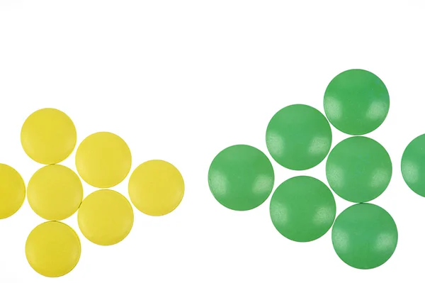 Желтые и зеленые таблетки на белом фоне — стоковое фото