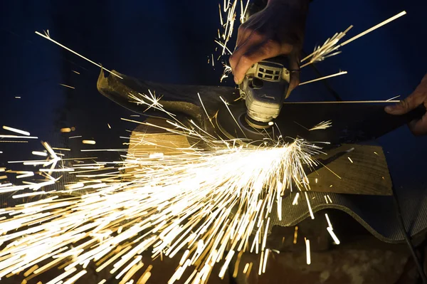 Worker cutting metal with grinder. Sparks while grinding iron — Stock Photo, Image